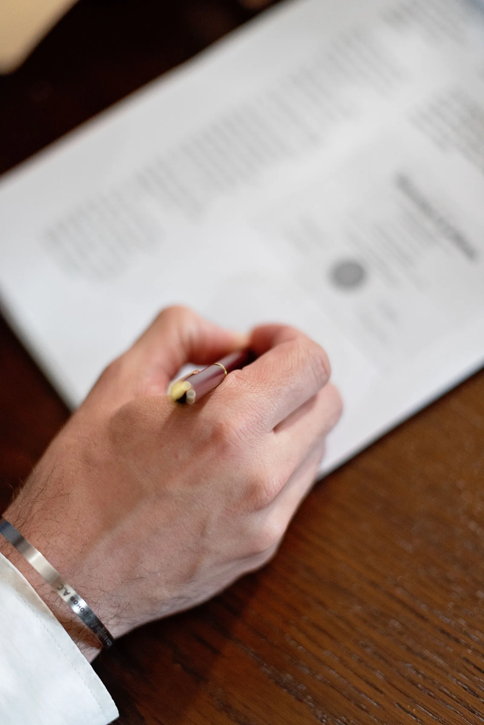 Primo piano di una mano che firma un mandato con la stilografica